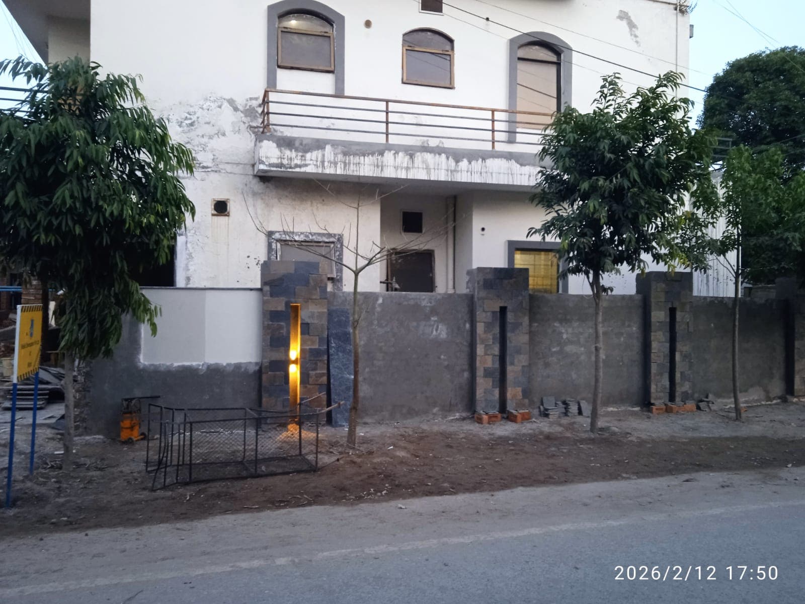 Completed two-storey house with stone-clad boundary wall