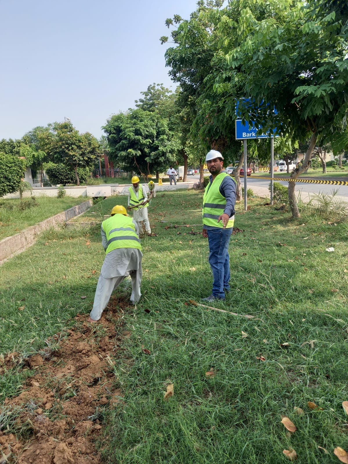 Crew laying cable along a roadside median
