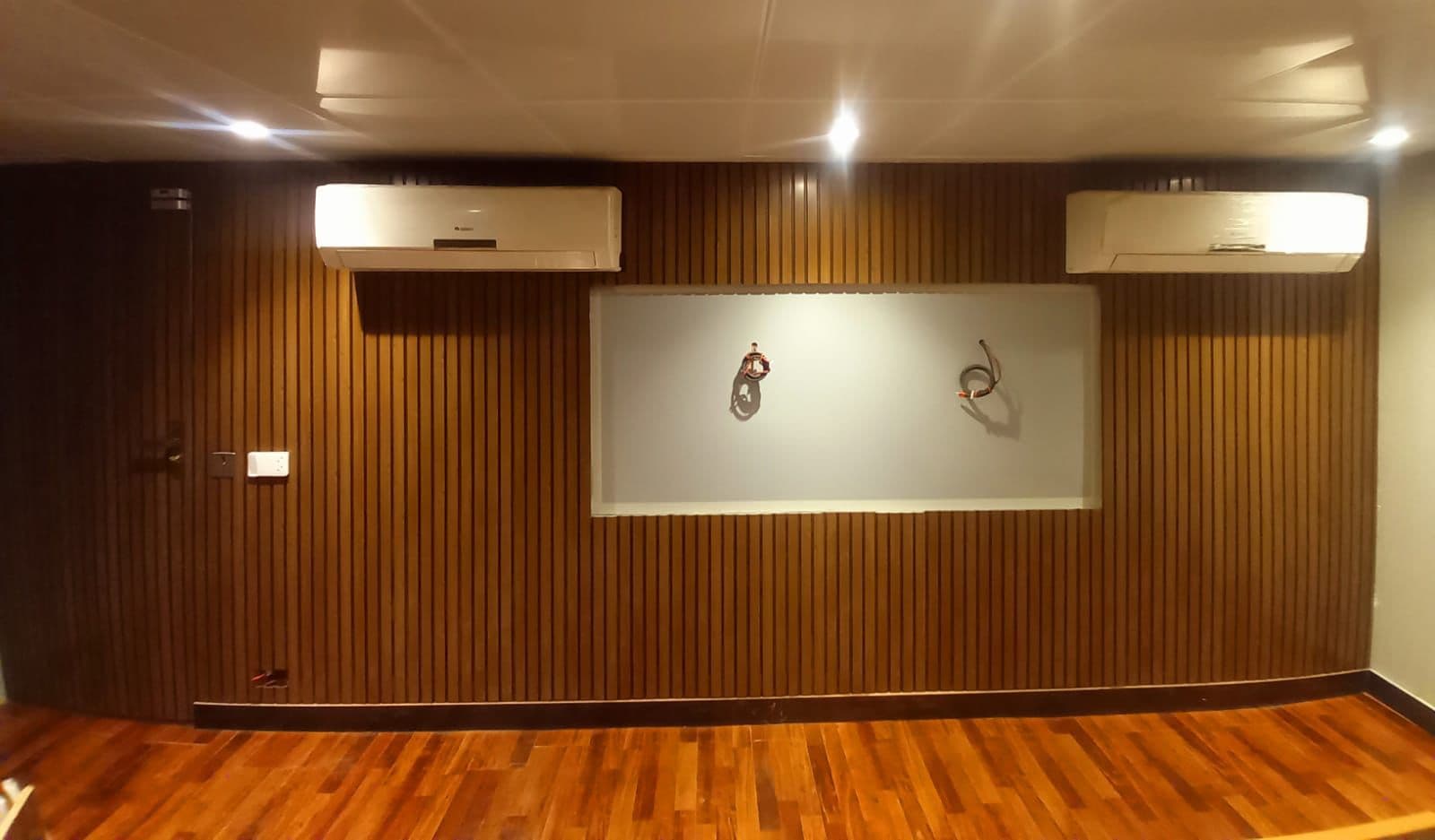 Wood-slat panelled office wall with split AC units