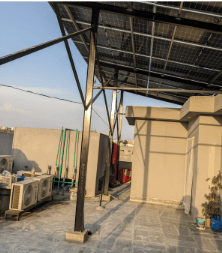 Rooftop solar panel canopy over a paved terrace
