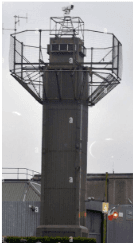 Concrete surveillance watch tower with railing platform and antenna mast