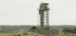 Steel-framed watch tower with observation cabin overlooking open terrain